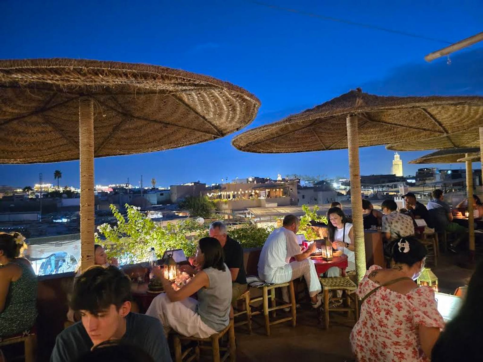 Parasol-shaded rooftop tables at dusk overlooking the medina, Café des Épices Marrakech