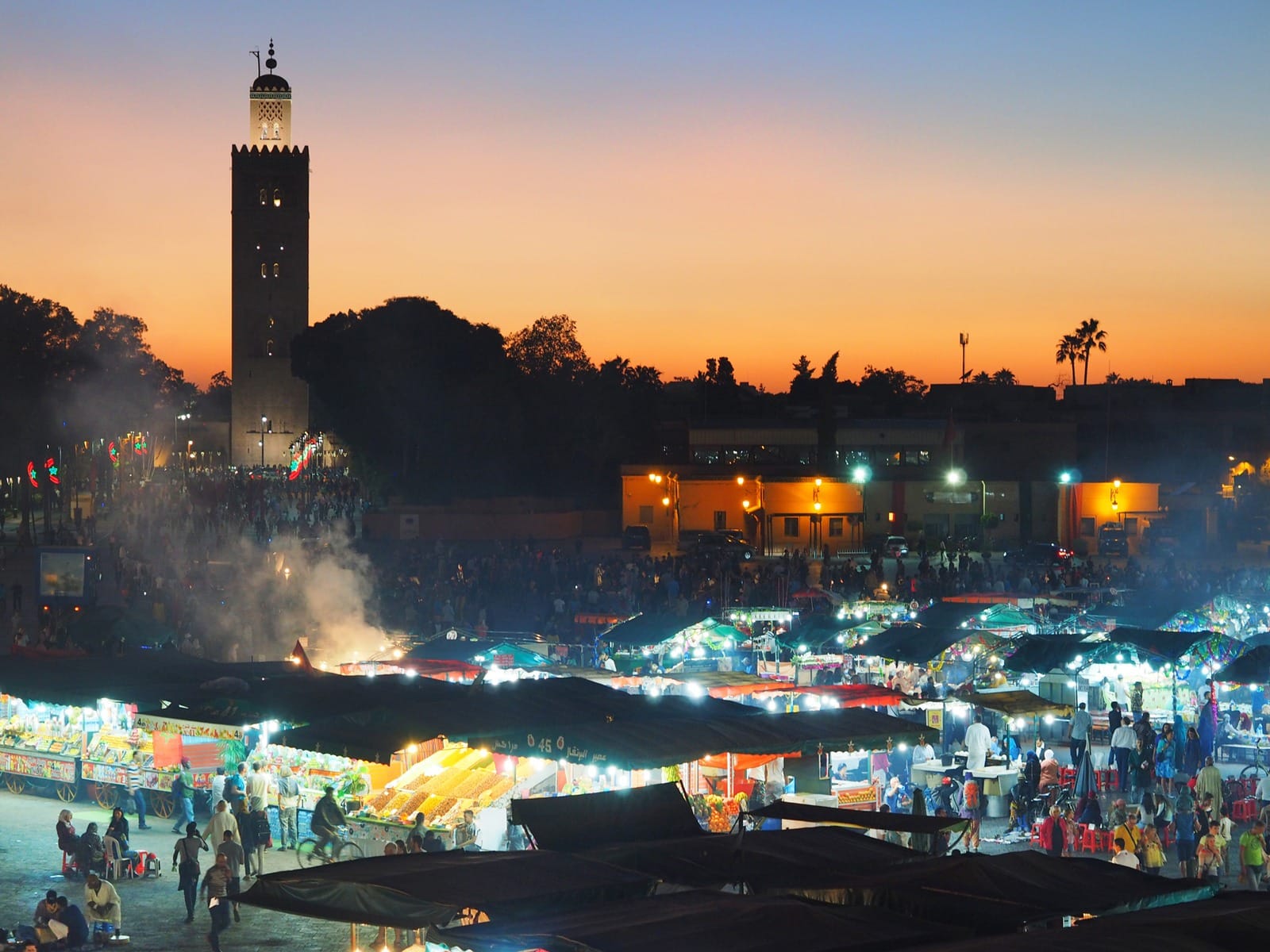 Lit food stall rows and rising smoke at dusk, Jemaa el-Fna