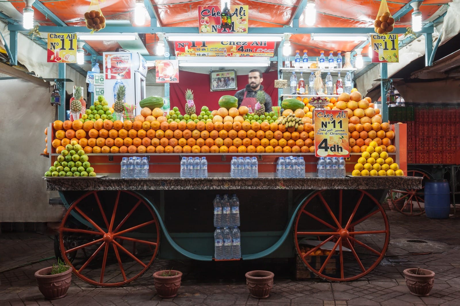 Numbered orange juice cart stacked with citrus and pineapples, Jemaa el-Fna